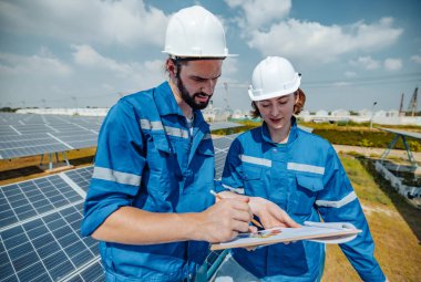 Güneş mühendisleri, standart gereksinimleri karşılayan hizalama, yüzey, güneş ışığı erişimi ve yapısal istikrar sağlamak için planlar ve çizimler kullanarak çiftlik alanlarındaki panel dizilerini görsel olarak incelerler..