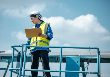 Güneş mühendisleri, standart gereksinimleri karşılayan hizalama, yüzey, güneş ışığı erişimi ve yapısal istikrar sağlamak için planlar ve çizimler kullanarak çiftlik alanlarındaki panel dizilerini görsel olarak incelerler..