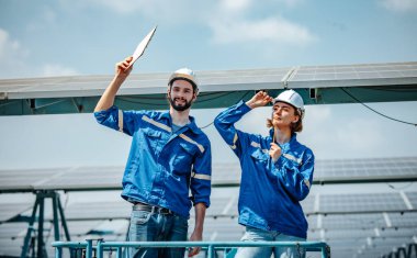 Güneş mühendisleri, standart gereksinimleri karşılayan hizalama, yüzey, güneş ışığı erişimi ve yapısal istikrar sağlamak için planlar ve çizimler kullanarak çiftlik alanlarındaki panel dizilerini görsel olarak incelerler..