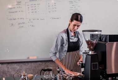 Genç yetişkin kahve makineleri menü yapmak için yetenekli baristlerle çalışır. Kahve makinesini kullanarak sıcak ve soğuk kahve yapmak. Üzerine süt köpüğü eklemek de dahil olmak üzere öğütme ve karıştırma deneyleri.