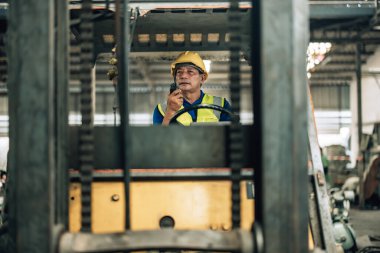 Folklift operatörü, folklörleri nakletmeye, dağıtmaya, malları raflara ve paletlere yerleştirmeye yönlendiriyor. Telsiz alıcısı aracılığıyla iş arkadaşları ve yöneticilerle ilgili işletim prosedürlerini güncellemeye devam et.
