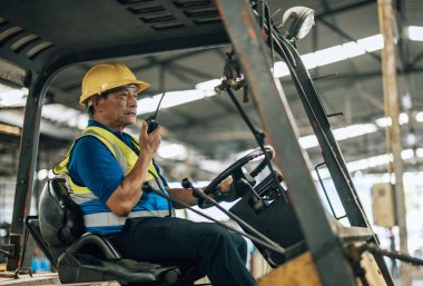 Folklift operatörü, folklörleri nakletmeye, dağıtmaya, malları raflara ve paletlere yerleştirmeye yönlendiriyor. Telsiz alıcısı aracılığıyla iş arkadaşları ve yöneticilerle ilgili işletim prosedürlerini güncellemeye devam et.