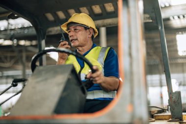 Folklift operatörü, folklörleri nakletmeye, dağıtmaya, malları raflara ve paletlere yerleştirmeye yönlendiriyor. Telsiz alıcısı aracılığıyla iş arkadaşları ve yöneticilerle ilgili işletim prosedürlerini güncellemeye devam et.
