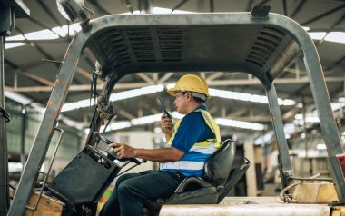 Folklift operatörü, folklörleri nakletmeye, dağıtmaya, malları raflara ve paletlere yerleştirmeye yönlendiriyor. Telsiz alıcısı aracılığıyla iş arkadaşları ve yöneticilerle ilgili işletim prosedürlerini güncellemeye devam et.