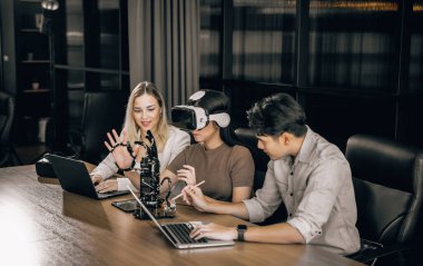 Üniversite öğrencileri eğitim robotlarıyla deney yapmak için araştırma ekibiyle işbirliği yapıyor. Sanal gerçeklik gözlüğü takmak, gerçek, etkileşimli durumları deneyimle ilişkilendirmeye yardımcı olur..