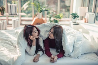 Asyalı lezbiyen çiftler oynuyorlar, gülümsüyorlar, dinleniyorlar yatak odasında battaniyenin altında birbirlerine bakıyorlar. Her gün, günün başında yapılması gereken rutin aktiviteler vardır..