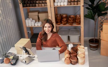 Vazo sahibi siparişleri internetten alıyor. Müşteri sorgularına ve ürün ve sevkiyatla ilgili endişelere uzun vadeli sadakat ve memnuniyeti artırmak için tepki. Ticari girişimcinin rutin çalışması