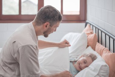 Babası kızını uyutmak için şarkı söylüyor, rahatlık, destek ve güvenlik sağlıyor. Hem fiziksel hem de duygusal ihtiyaçlarını karşılamaya odaklan. Çocuklar bazen uyuyormuş gibi yaparken mutlu davranırlar..