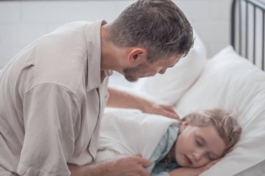 Babası kızını uyutmak için şarkı söylüyor, rahatlık, destek ve güvenlik sağlıyor. Hem fiziksel hem de duygusal ihtiyaçlarını karşılamaya odaklan. Çocuklar bazen uyuyormuş gibi yaparken mutlu davranırlar..