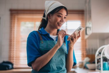 Hevesli ev temizlikçisi kadın çeşitli görevlerde sorumluluk sahibi. Paspas, süpürge, çamaşır makinesi, temizlik malzemeleri, temizlik malzemeleri mobilya, cam, zemin, giysi, bulaşık....