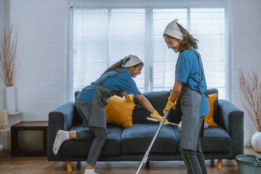 Hevesli ev temizlikçisi kadın çeşitli görevlerde sorumluluk sahibi. Paspas, süpürge, çamaşır makinesi, temizlik malzemeleri, temizlik malzemeleri mobilya, cam, zemin, giysi, bulaşık....