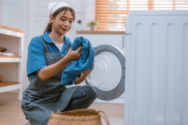 Hevesli ev temizlikçisi kadın çeşitli görevlerde sorumluluk sahibi. Paspas, süpürge, çamaşır makinesi, temizlik malzemeleri, temizlik malzemeleri mobilya, cam, zemin, giysi, bulaşık....