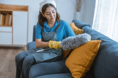 Hevesli ev temizlikçisi kadın çeşitli görevlerde sorumluluk sahibi. Paspas, süpürge, çamaşır makinesi, temizlik malzemeleri, temizlik malzemeleri mobilya, cam, zemin, giysi, bulaşık....