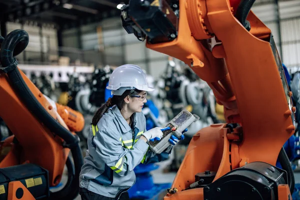 机器人技师使用控制面板操作 维护工厂中的机器人臂 通过监测 分析数据库和整合流程 确保生产力 效率和安全 — 图库照片