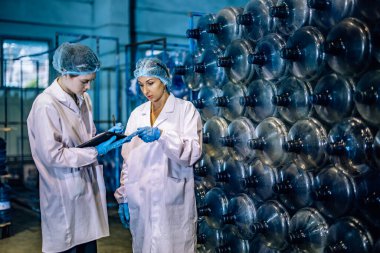 Tecrübeli imalat danışmanı koçları ve kalite kontrol stajyeri. İçme suyu dağıtımının kusursuz ve etkili bir şekilde incelenmesi için envanter, fiziksel standart