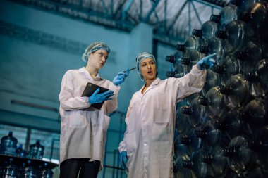 Tecrübeli imalat danışmanı koçları ve kalite kontrol stajyeri. İçme suyu dağıtımının kusursuz ve etkili bir şekilde incelenmesi için envanter, fiziksel standart