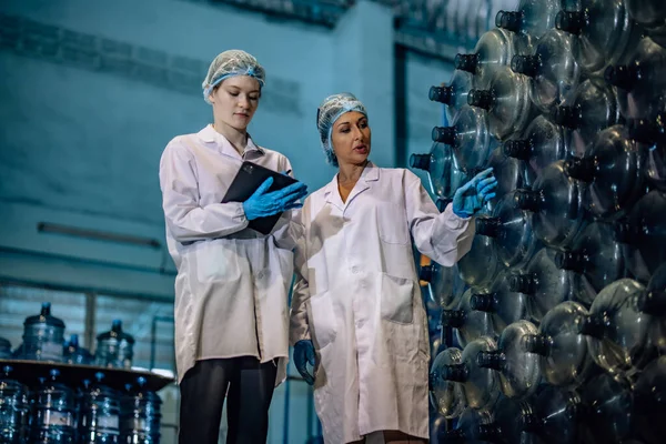 stock image Experienced manufacturing supervisor coaches and mentors trainee in quality control. Examining sequence, inventory, physical standard for precise and effective seamless of drinking water distribution
