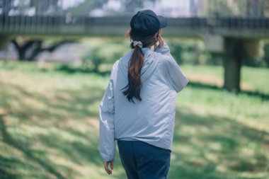 Modern kıyafetler giymiş modaya uygun bayan koşucular ritmik ritimlerde huzur buluyor. Enerjiyi hayatın sabit ve sakin akışının ortasında şarj et. Kamu yolunda koşarken sükuneti kucakla.