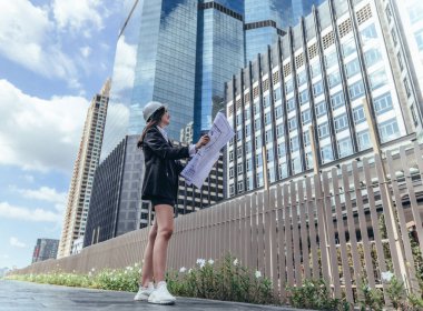 Yetenekli kadın mimar, Skytrain ve çevresindeki inşaat alanlarını titizlikle inceliyor. Planları ve mimari yapıları karşılaştırıyor. Proje onayı için hassas hesaplamalar uygulanıyor.