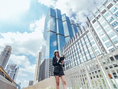 Yetenekli kadın mimar, Skytrain ve çevresindeki inşaat alanlarını titizlikle inceliyor. Planları ve mimari yapıları karşılaştırıyor. Proje onayı için hassas hesaplamalar uygulanıyor.