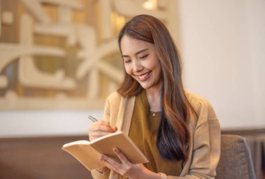 Asyalı kadın yönetici bir kahve dükkanında bulunurken kapsamlı bir analiz yaparak olası bir yatırım projesi için uzaktan onay verdi. Genişleme için dikkatlice tasarlanmış stratejik karar.