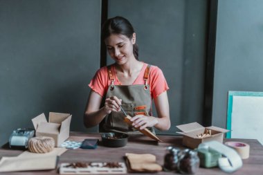 Küçük bir kafe sahibi sürdürülebilir dairesel ekonomiyi teşvik ediyor, toplama, paketleme, kahve çekirdekleri siparişlerini etiketleme, atıkları azaltma ve çevre dostu çevrimiçi alışveriş için geri dönüşümlü materyallerle nakliye.