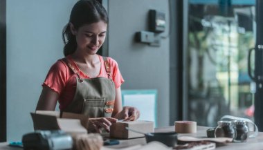 Küçük bir kafe sahibi sürdürülebilir dairesel ekonomiyi teşvik ediyor, toplama, paketleme, kahve çekirdekleri siparişlerini etiketleme, atıkları azaltma ve çevre dostu çevrimiçi alışveriş için geri dönüşümlü materyallerle nakliye.