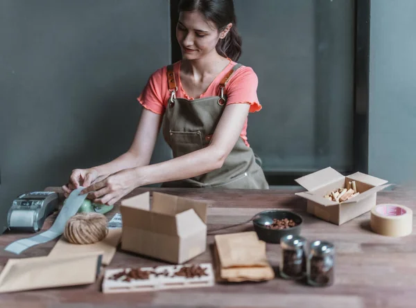 stock image A small cafe owner promotes the sustainable circular economy, picking, wrapping, labeling coffee bean orders , reducing waste, and shipping with recycled materials for eco-friendly online shopping.