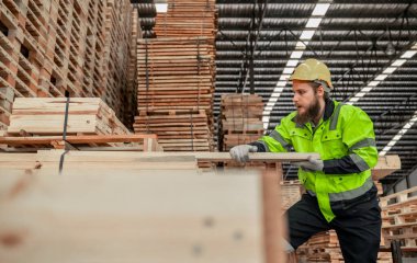 Ölçmek ve doğru boyutu hesaplamak için iştaşlarını seçerken ve taşırken saptanmış bir odun çevirici atışı. kesme, şekil verme, döndürme, pürüzsüz, ahşap fiksasyonları gereksinimlere göre dengelemek için el ve güç araçları kullanarak