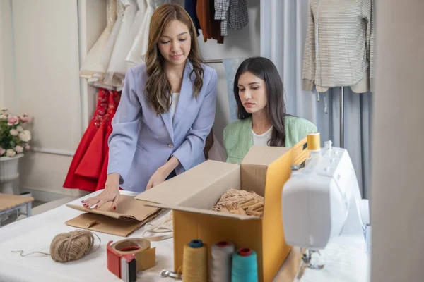 Designers reduce environmental impact by using recycled, sustainable materials for apparel production, eco-friendly recycled packaging, and local transportation methods for eco-conscious online orders