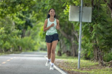 Modern kıyafetler giymiş modaya uygun bayan koşucular ritmik ritimlerde huzur buluyor. Enerjiyi hayatın sabit ve sakin akışının ortasında şarj et. Kamu yolunda koşarken sükuneti kucakla.