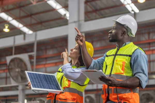 Metal sheet workers at factory plan to install solar panels on roof, promoting renewable energy, reducing costs, registering carbon credits for sustainable and efficient way to combat climate change.