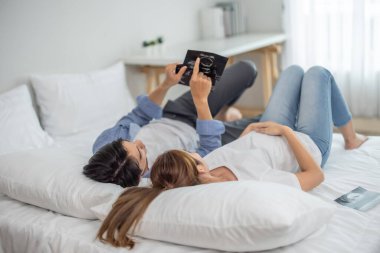 Asyalı çiftler ultrason görüntülerini tararken hamileliğin coşkusunu ve heyecanını kucaklarlar. Bebeğin rahmindeki sağlık, cinsiyet ve gelişimi ortaya çıkar. Mutluluk ve memnuniyet aile içinde bağı güçlendirir.
