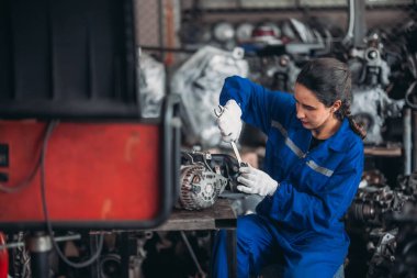 Araba servisi teknisyenleri depodaki motor parçalarını inceliyor, inceliyor. Hassas onarımlar, modifikasyonlar ve montaj için kaliteli dişlileri ve aletleri dikkatlice seçiyor. En uygun araç performansı sağlanıyor