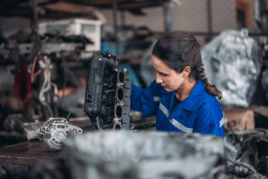 Araba servisi teknisyenleri depodaki motor parçalarını inceliyor, inceliyor. Hassas onarımlar, modifikasyonlar ve montaj için kaliteli dişlileri ve aletleri dikkatlice seçiyor. En uygun araç performansı sağlanıyor