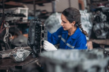 Araba servisi teknisyenleri depodaki motor parçalarını inceliyor, inceliyor. Hassas onarımlar, modifikasyonlar ve montaj için kaliteli dişlileri ve aletleri dikkatlice seçiyor. En uygun araç performansı sağlanıyor