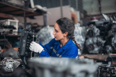 Araba servisi teknisyenleri depodaki motor parçalarını inceliyor, inceliyor. Hassas onarımlar, modifikasyonlar ve montaj için kaliteli dişlileri ve aletleri dikkatlice seçiyor. En uygun araç performansı sağlanıyor