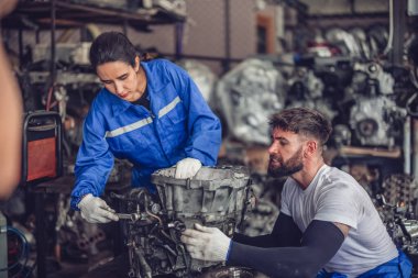 Araba servisi teknisyenleri depodaki motor parçalarını inceliyor, inceliyor. Hassas onarımlar, modifikasyonlar ve montaj için kaliteli dişlileri ve aletleri dikkatlice seçiyor. En uygun araç performansı sağlanıyor