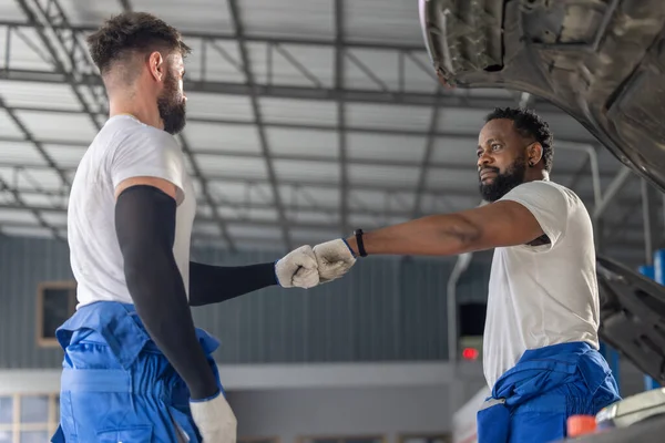 Auto mechanics create team-building ritual, connection, mutual understanding. Cultivating positive atmosphere, strengthen spirit and relationships, motivating teammates for success in garage workshop