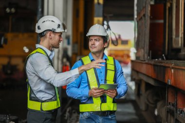 Yazılım mühendisleri, lokomotif işlemleri için akıllı enerji analizi uygulamasını geliştirmenin yollarını tartışıyor. Gerçek zamanlı izleme veri kullanımını optimize eder ve verimli tüketim içgörülerini analiz eder.