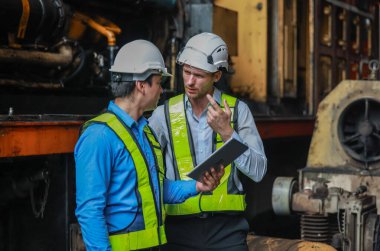 Yazılım mühendisleri, lokomotif işlemleri için akıllı enerji analizi uygulamasını geliştirmenin yollarını tartışıyor. Gerçek zamanlı izleme veri kullanımını optimize eder ve verimli tüketim içgörülerini analiz eder.