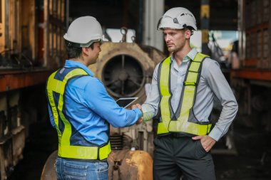 Yazılım mühendisleri, lokomotif işlemleri için akıllı enerji analizi uygulamasını geliştirmenin yollarını tartışıyor. Gerçek zamanlı izleme veri kullanımını optimize eder ve verimli tüketim içgörülerini analiz eder.