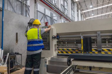 Karton üretim teknisyeni otomatik yazdırma makinesinin etkin kurulumunu sağlar, maddi hizalama, kalite kontrolü ve sorunların hızlı bir şekilde giderilmesi üzerine odaklanır..