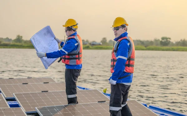 Dva Solární Inženýři Pozorně Studují Soubor Plánů Zároveň Provádějí Přesnou — Stock fotografie