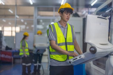 Robotik stajyerler, bir robotik eğitim akademisinin kontrol odasındaki makine monitörleri üzerindeki uygulamalı dersler ve gösteriler yoluyla çalışma, programlama ve sorun çözme tekniklerini öğrenirler..