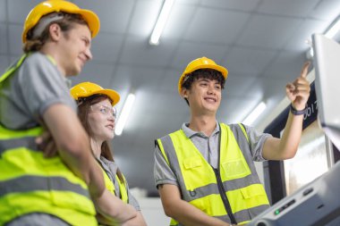 Robotik stajyerler, bir robotik eğitim akademisinin kontrol odasındaki makine monitörleri üzerindeki uygulamalı dersler ve gösteriler yoluyla çalışma, programlama ve sorun çözme tekniklerini öğrenirler..