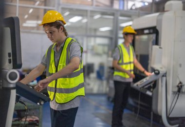 Robotik stajyerler, bir robotik eğitim akademisinin kontrol odasındaki makine monitörleri üzerindeki uygulamalı dersler ve gösteriler yoluyla çalışma, programlama ve sorun çözme tekniklerini öğrenirler..