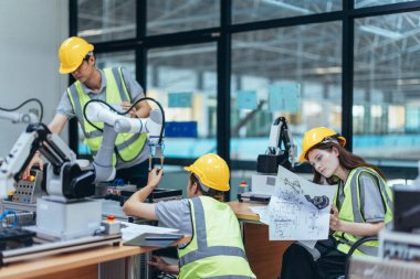 Stajyerler, bir üretim akademisinde robot sistem programlama üzerine pratik dersler sırasında teknik tasarım, program, kontrol robotik kolu analiz ederler. Tecrübe ve becerilerin vurgulanması.