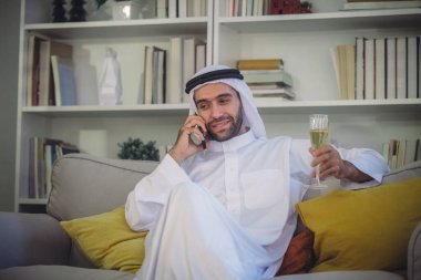Sheikh, CEO in arb dress, supervising business, distant meetings, and communication via video call with the team with a smile gesture. Overseeing operations as a leader, showcasing responsibilities. clipart
