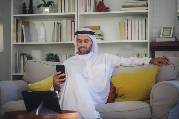 Sheikh, CEO in arb dress, supervising business, distant meetings, and communication via video call with the team with a smile gesture. Overseeing operations as a leader, showcasing responsibilities.